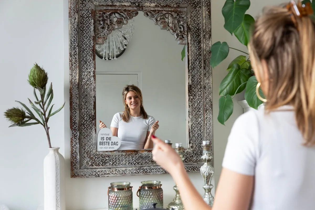 Vrouw kijkt naar zichzelf in de grote spiegel in de praktijk