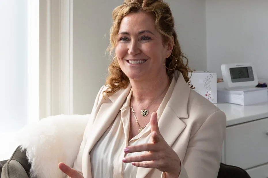 Ilse Bink legt lachend iets uit tijdens een gesprek in haar praktijk