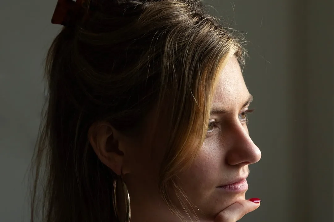 Jonge vrouw kijkt peinzend opzij
