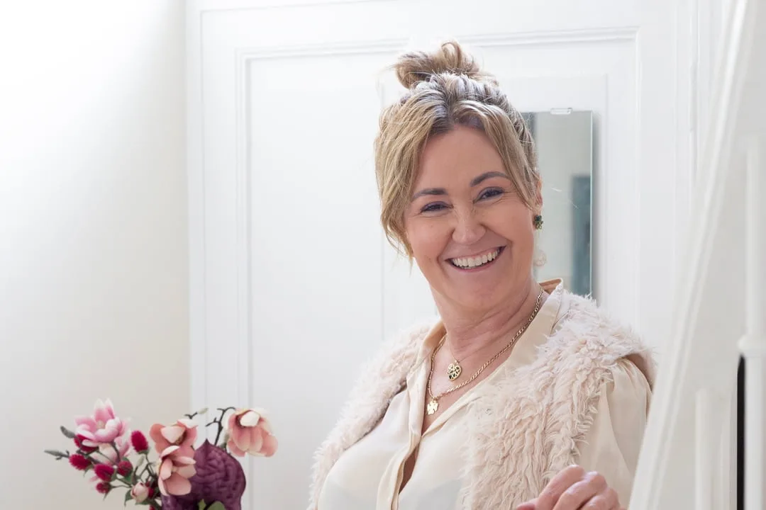 Ilse Bink lacht naast een vaas met bloemen in haar praktijk